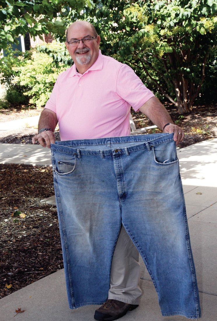 Len Dompke holds up the pants he wore to his very first “Jumpstart Your Health” class. Dompke is grateful to Lions for the support he needed to make lasting changes. Photo courtesy of Edward-Elmhurst Health.