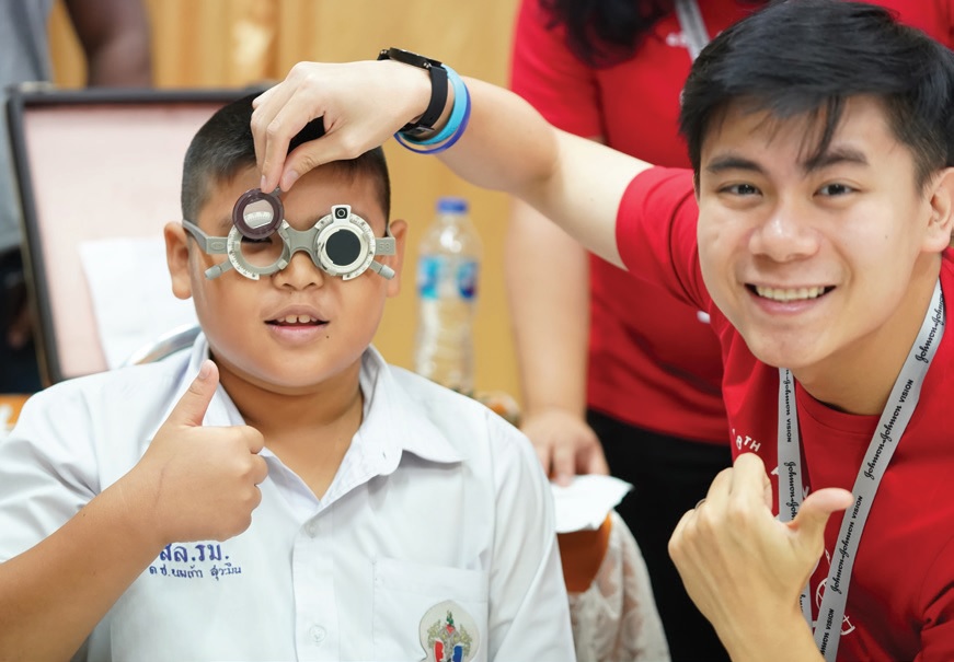 A Sight for Kids volunteer screens the vision of a young boy in Thailand.