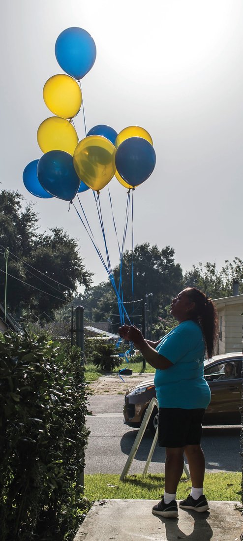 Catalina Morales ties balloons to a mailbox at the Dade City club’s office to welcome community members to the free health clinic. PHOTOS BY ZACK WITTMAN