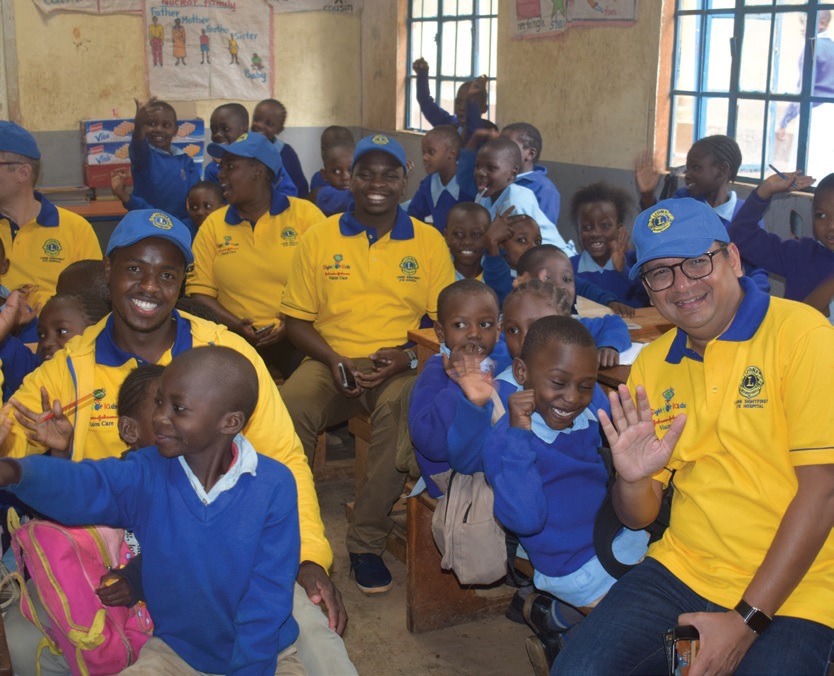 Lions and Johnson & Johnson Vision team members spend time with children at a vision screening in Kenya.