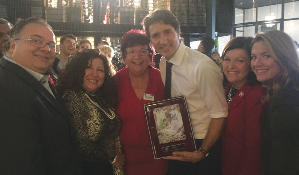 (Left to right) Canadian Member of Parliament (MP) Ramez Ayoub, New Voices Coordinator Liliane Farhat, PDG Nicole LePage, Prime Minister Justin Trudeau, MP Linda Lapointe, and Madame Sophie Grégoire Trudeau pose with the Prime Minister's new Lions Clubs Peace plaque.