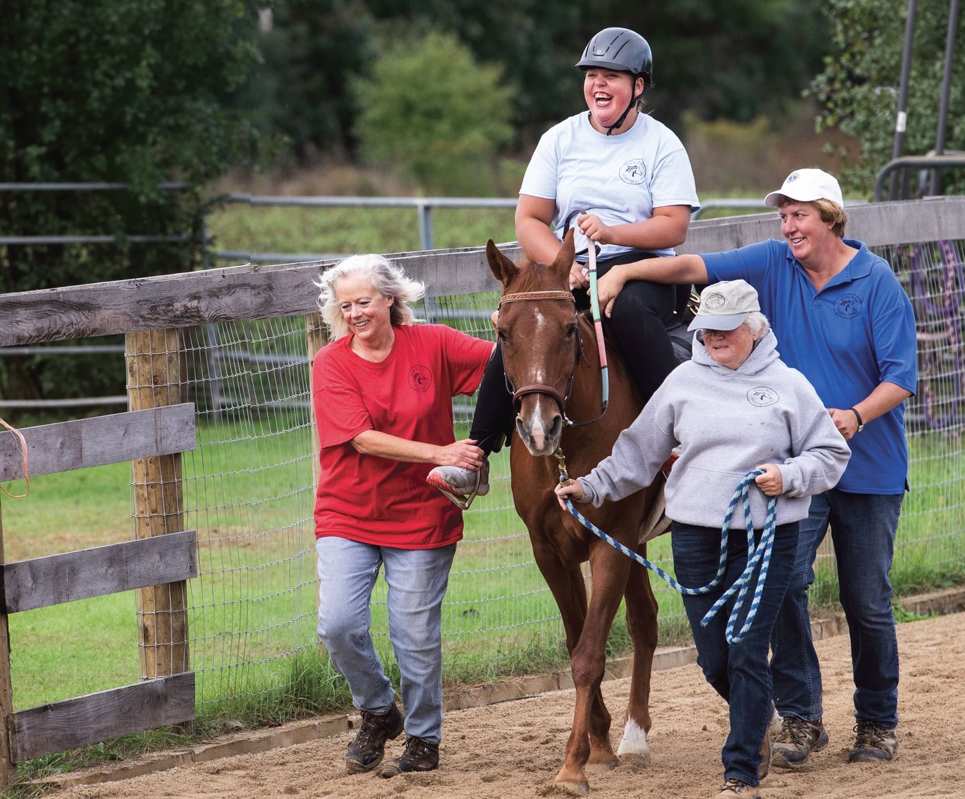 Three women lead a young girl as she rides a horse.