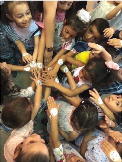 Children in Armenia show off their Lions Kid Sight Pediatric Screening stickers they received when the Brookfield Lions in Connecticut traveled to their country to conduct vision screenings.