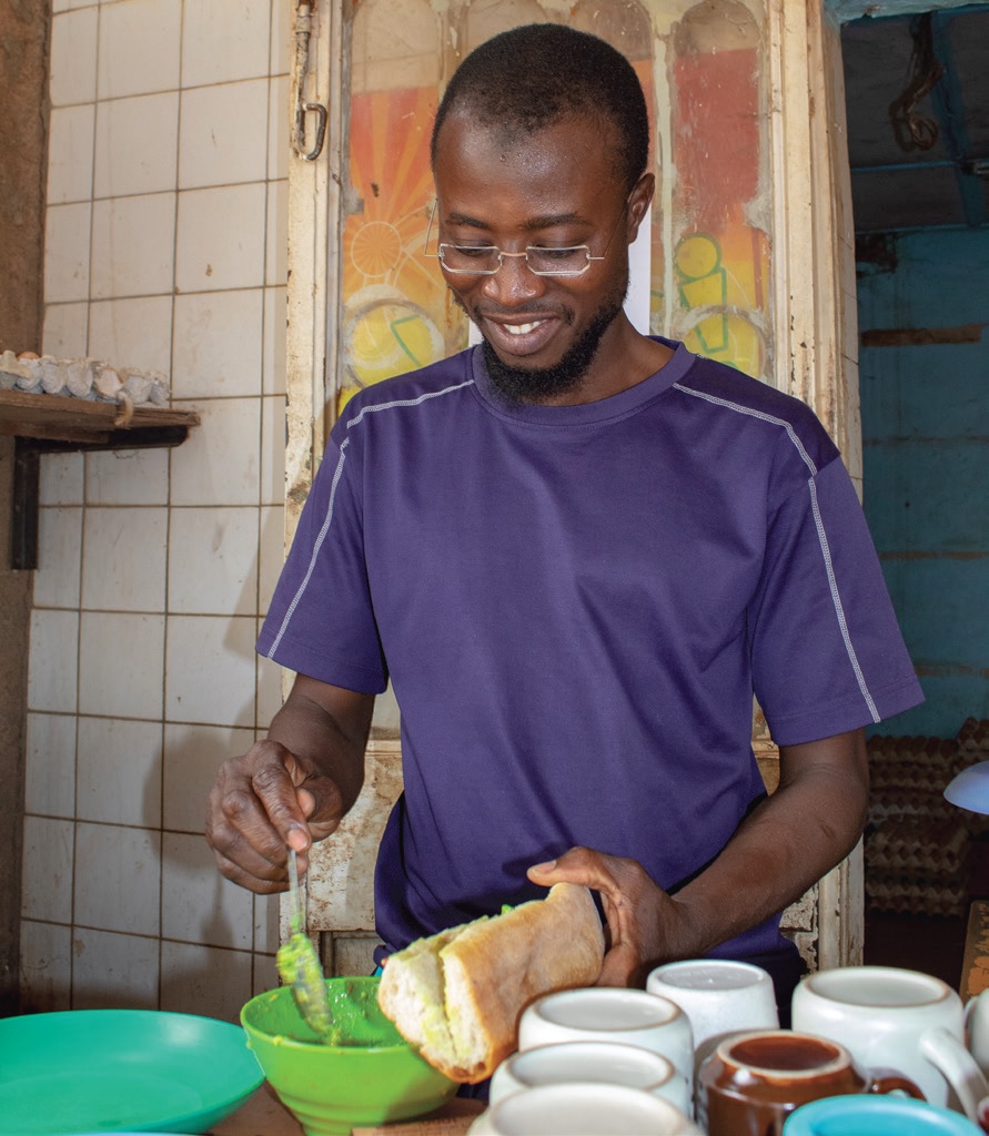 Idrissa prepares his specialty, an avocado sandwich.