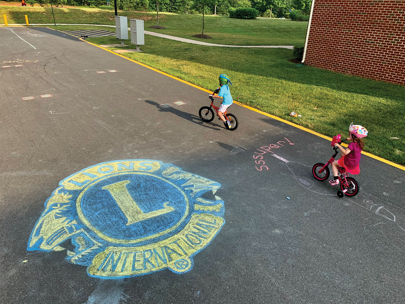 Kids bike next to a Lions emblem made out of chalk.