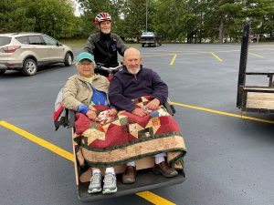 Older couple smiles in a trishaw