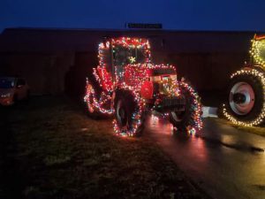A large tractor covered in Christmas lights.