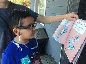 Boy uses special glasses to read