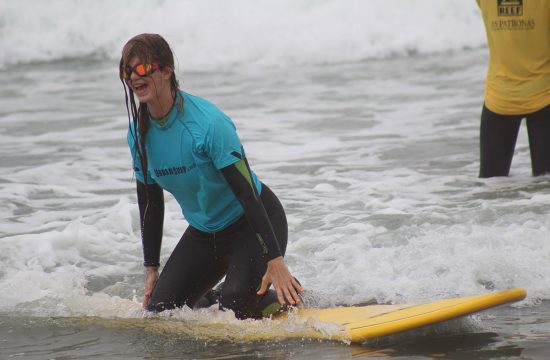 Blind woman kneeling on surfboard