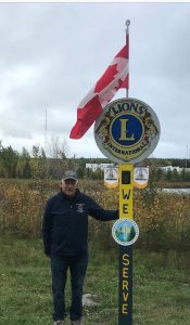 man holding Lions Club International sign and American flag