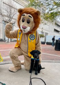 Lions Clubs International Lions Costume poses with puppy