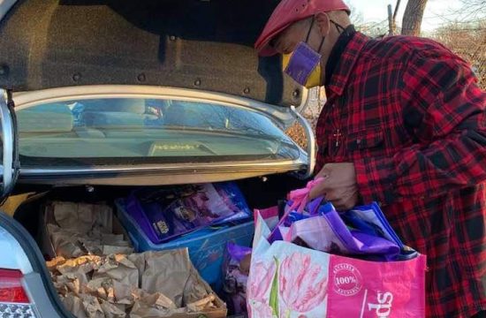 Man puts groceries in car trunk