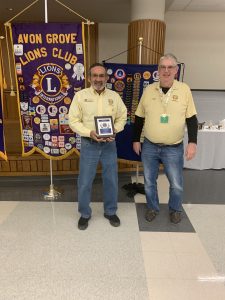 Lions club members pose with a plaque