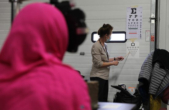 Lions club member gives refugee an eye exam