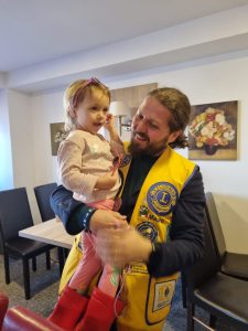 Lions Clubs International member holds refugee child