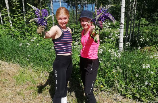 Girls hold up invasive species of plant