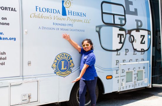 Girl pointing to Lions Clubs International logo on side of truck