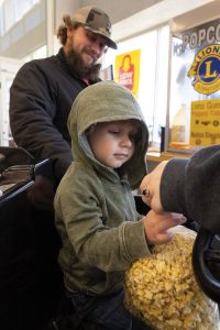 A little boy checks out a bag of popcorn from Marshalltown Lions. 