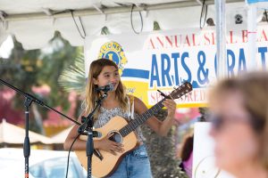 Girls sings and plays guitar at Seal Beach Lions Club Arts and Crafts Faire