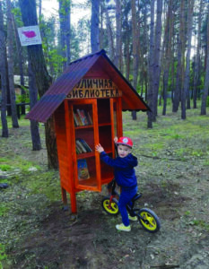 A young visitor to the “Fairy Forest” browses the little library.